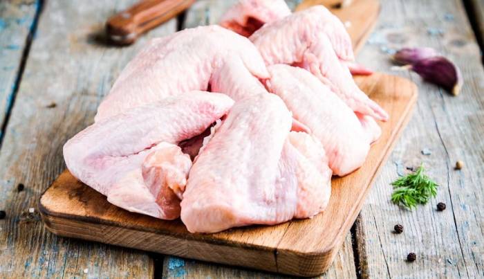 Свежие куриные крылышки Крылышки на доске