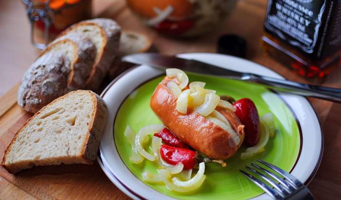 Маринованная сарделька с хлебом Маринованная сарделька на тарелке