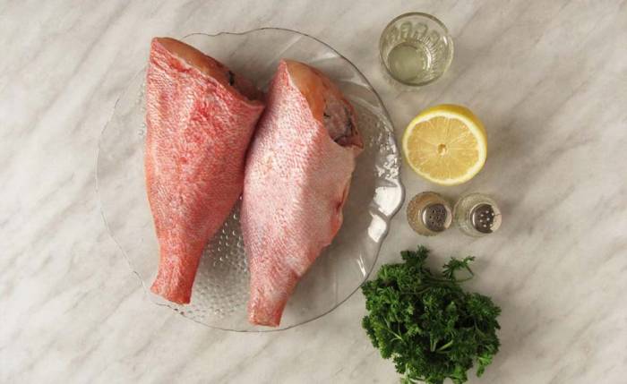 Ингредиенты для приготовления морского окуня на решётке Окуни, лимон, масло и зелень