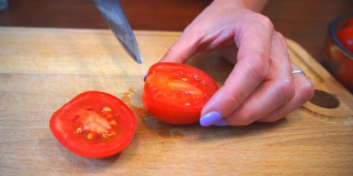 Разрезание помидора пополам Помидор и нож
