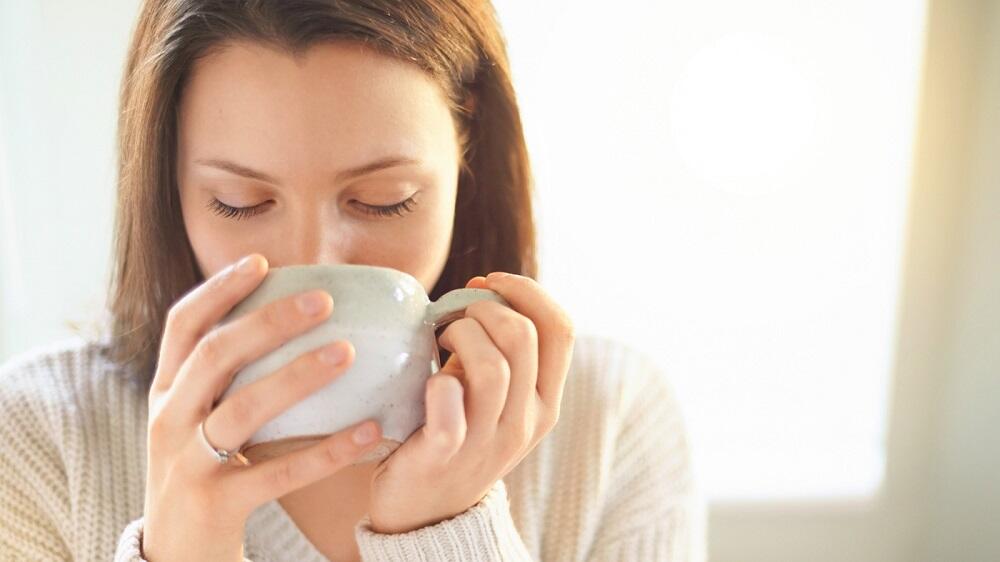 Употребление отвара шиповника Девушка пьет из кружки