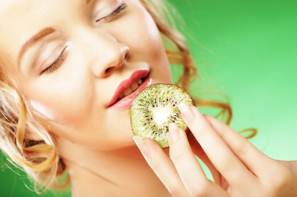 Польза от употребления киви Девушка с кусочком киви