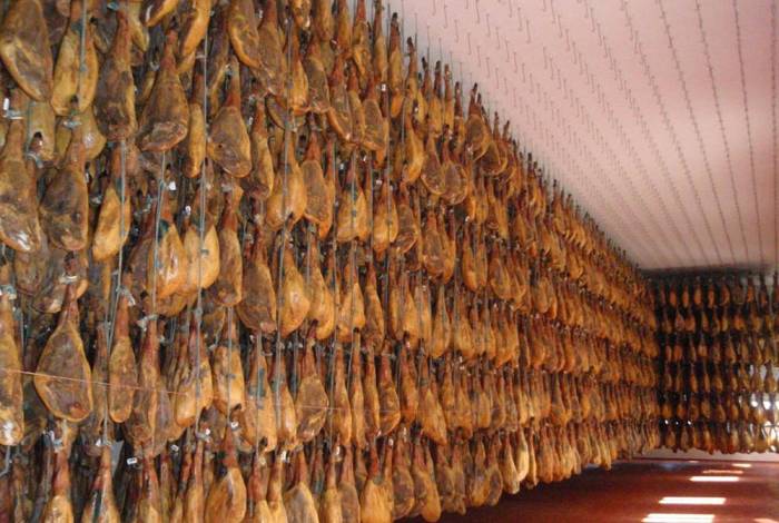 Созревшие заготовки вяленого мяса хамон в специальном погребном хранилище Хамон и заготовка