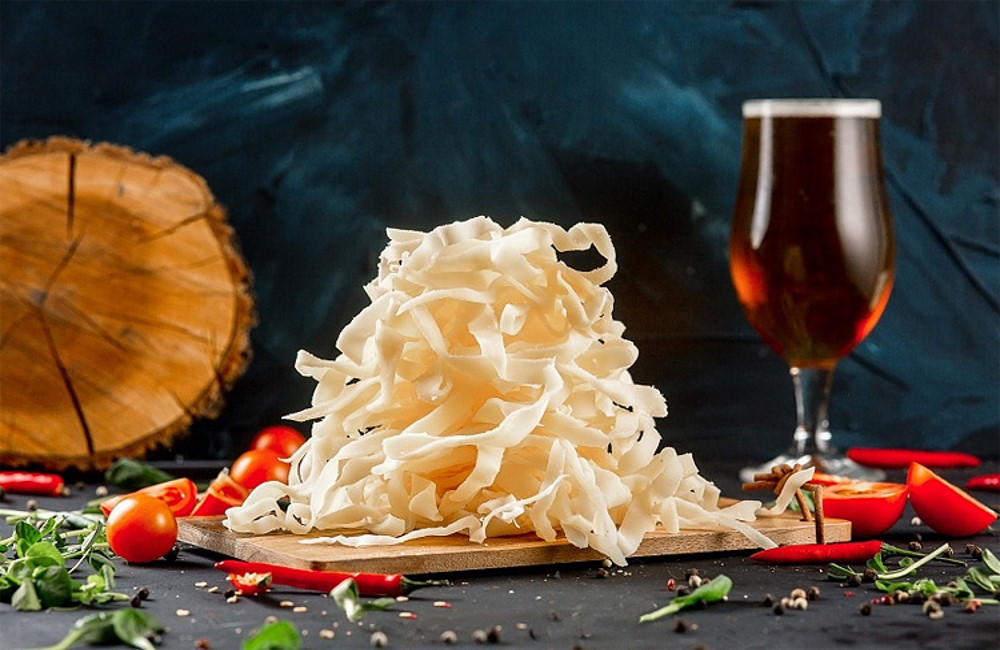 Вяленый кальмар с бокалом темного пива Горка вяленого кальмара с бокалом темного пива