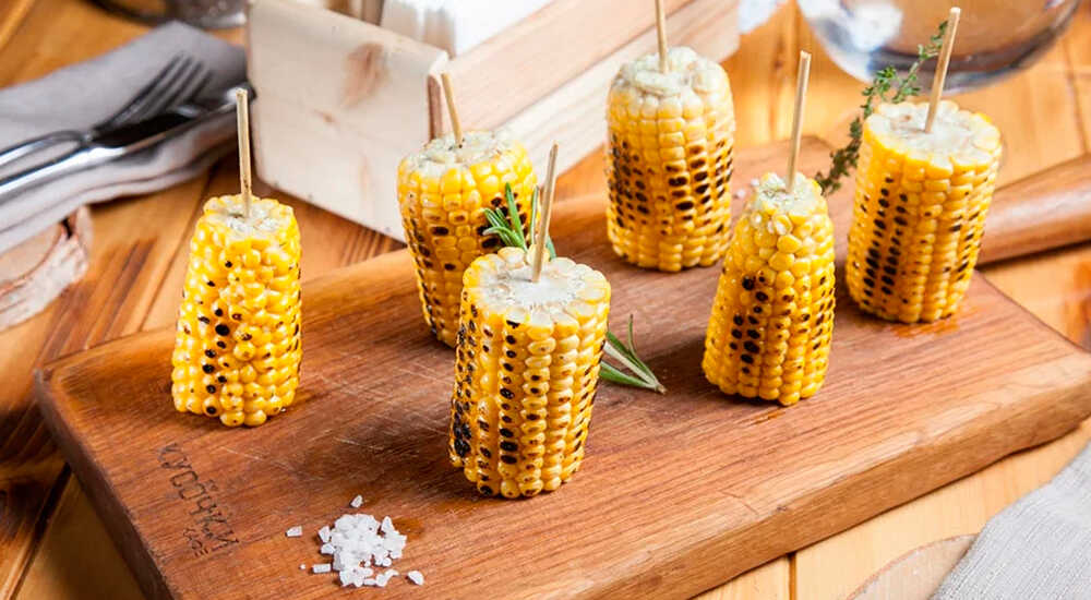 Приготовленная кукуруза-гриль с чесноком, зеленым луком Кукуруза с чесноком, зеленым луком