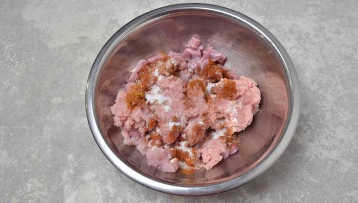 Добавление соли и специй к кускам индейки Куски индейки со специями