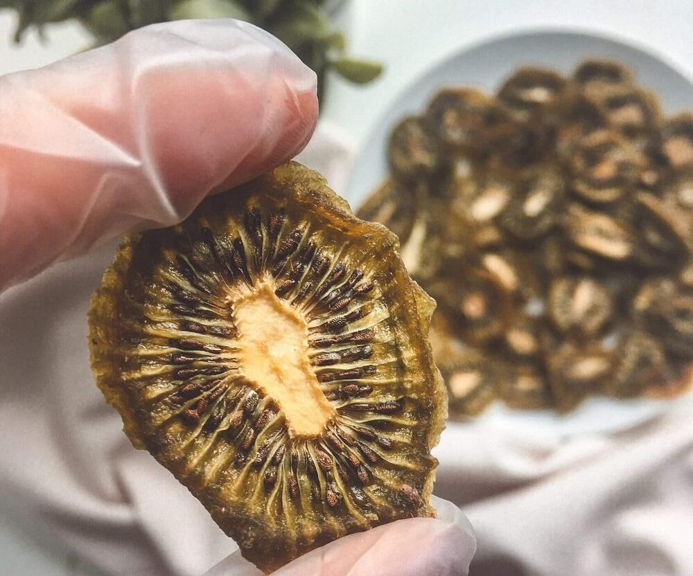 Чипсы из киви Кусочек сушеного киви в руках