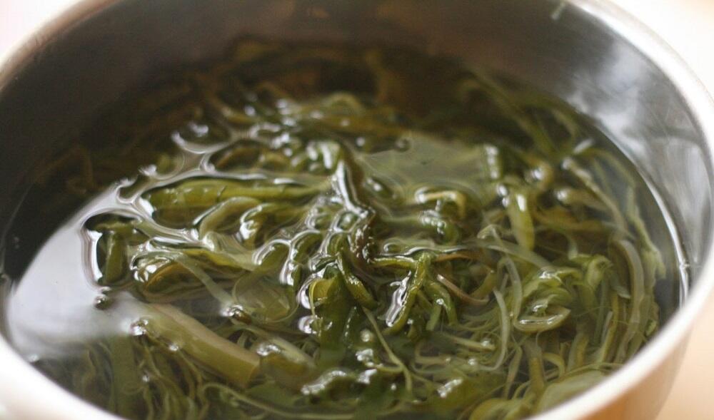 Морская капуста, замоченная в воде Ламинария в кастрюле с водой