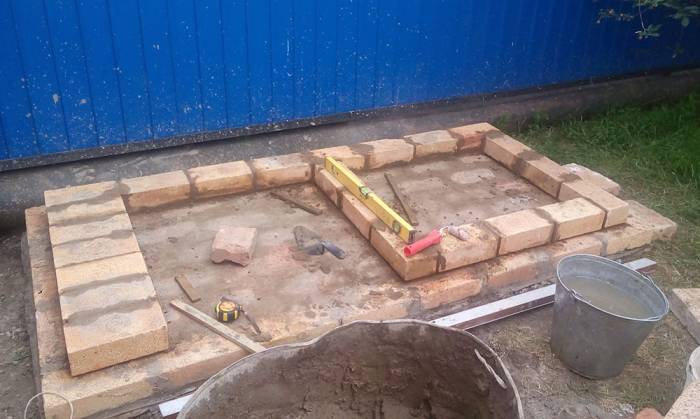 Кладка первого ряда кирпичей Мангал и первый ряд
