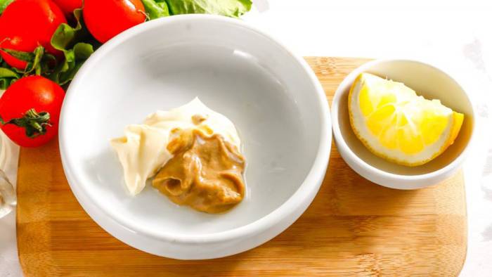 Смешивание майонеза, сока лимона и горчицы Майонез, сок лимона и горчица