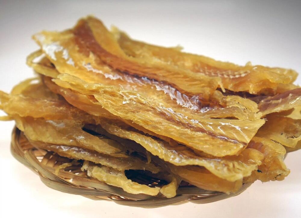 Филе сушеного минтая Минтай сушеный лежит на плетеной тарелочке