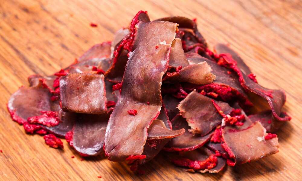 Нарезка бастурмы на столе Нарезанное вяленое мясо говядины