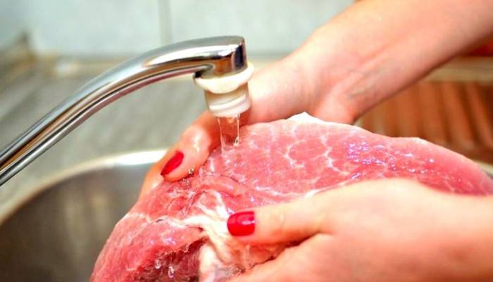 Промывание свиного окорока под проточной водой Окорок и вода