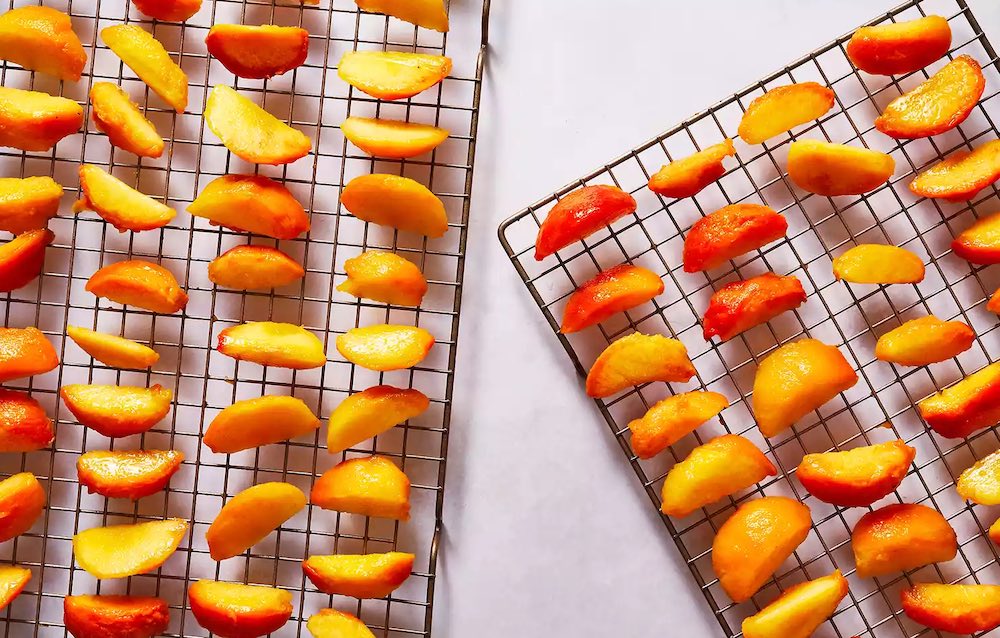 Выкладывание персиков на решётку для сушки на солнце Персики для улицы