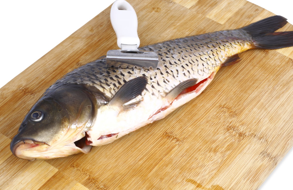 Потрошёная тушка карпа На деревянной доске тушка потрошёного карпа