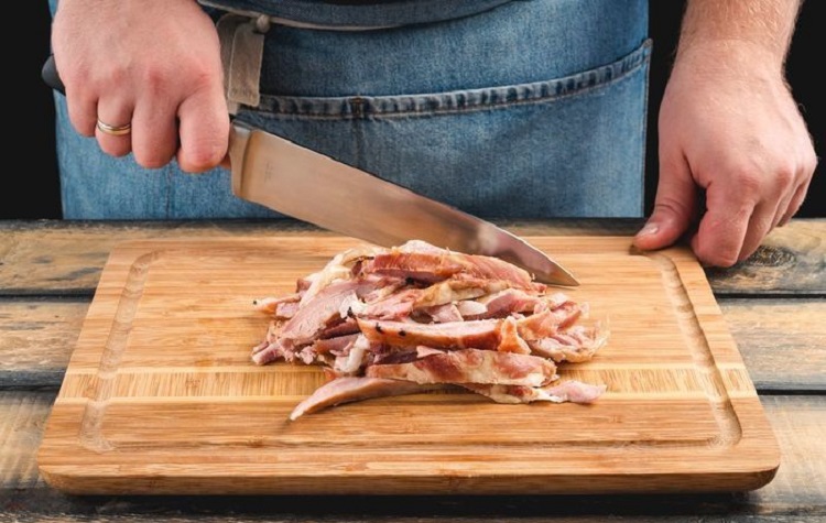Разрезание копчёных рёбер на небольшие кусочки Разрезание копчёных рёбер