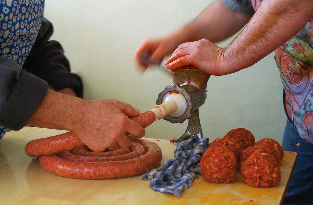 Начинение колбасы с помощью ручной мясорубки Ручная мясорубка и колбаса