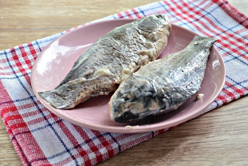 Две рыбы в маринаде из майонеза Две тушки рыбы смазанные майонезом