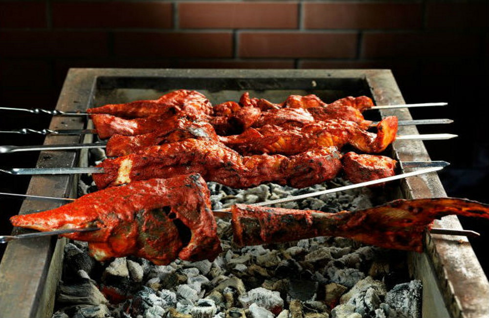 Щука замаринованная в томатном соусе жарится на углях Щука в томатном соусе на мангале