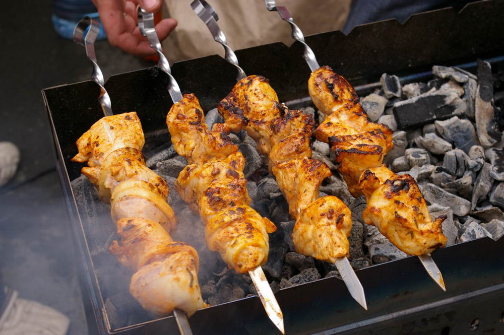 Шашлык жарится на мангале Шашлык на шампурах жарится на мангале