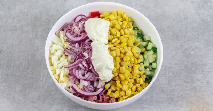 Смешивание ингредиентов классического салата из колбасы и перца Смешивание ингредиентов классического салата