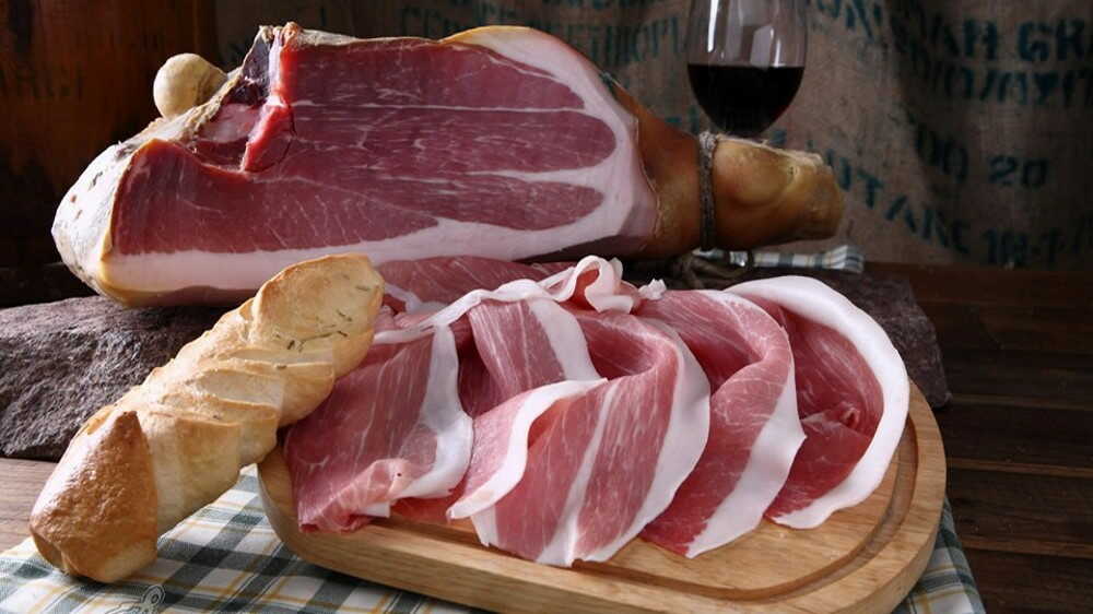 Нарезанная слайсами вяленая свинина На деревянной доске нарезанная слайсами вяленая свинина