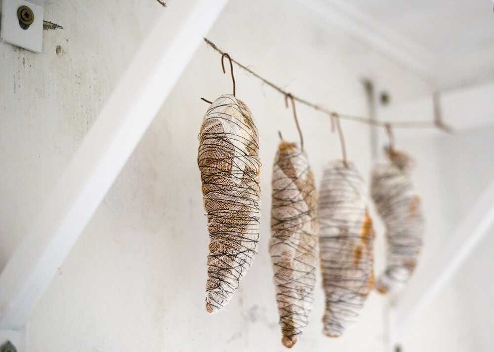 Мясо в марле вялится на веревке Вяленое мясо в марле висит на веревке