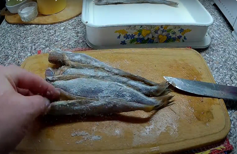 Путассу солят сухим методом На деревянной доске солят тушки рыбы