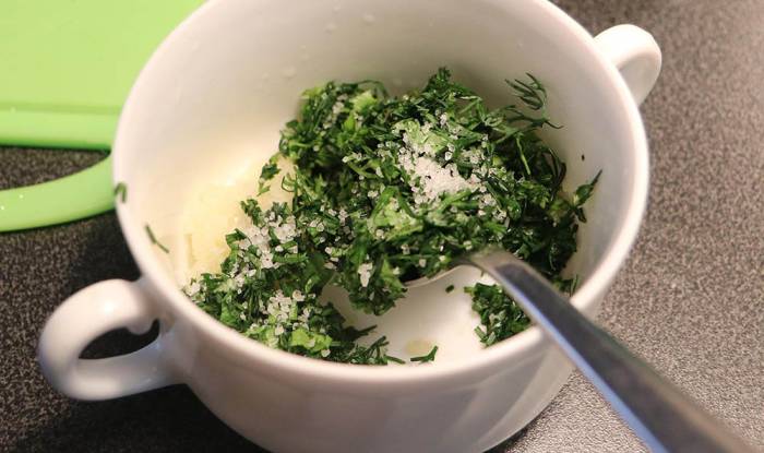 Смешение ингредиентов сметанного соуса Зелень, сметана, чеснок и соль